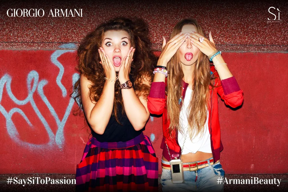 Two guests posing in a Giorgio Armani Sì Passione branded photo.